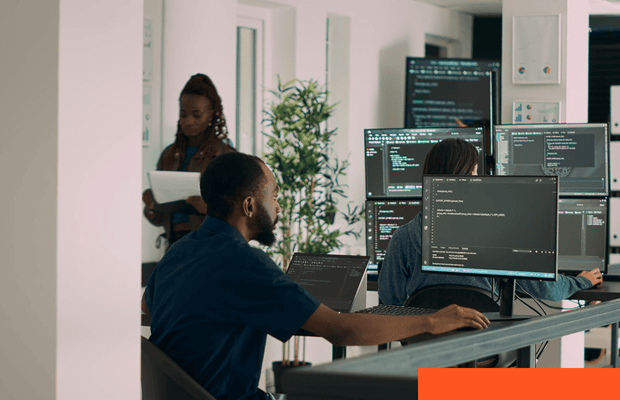 AI Infrastructure and MLOps Multiple monitors displaying software code in a technical workspace