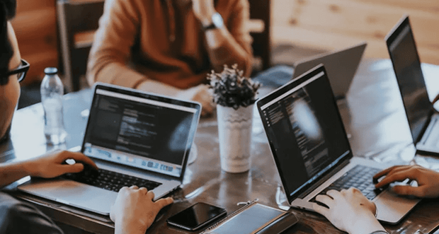 Colleagues working on laptops as part of an AI chatbot lead generation process