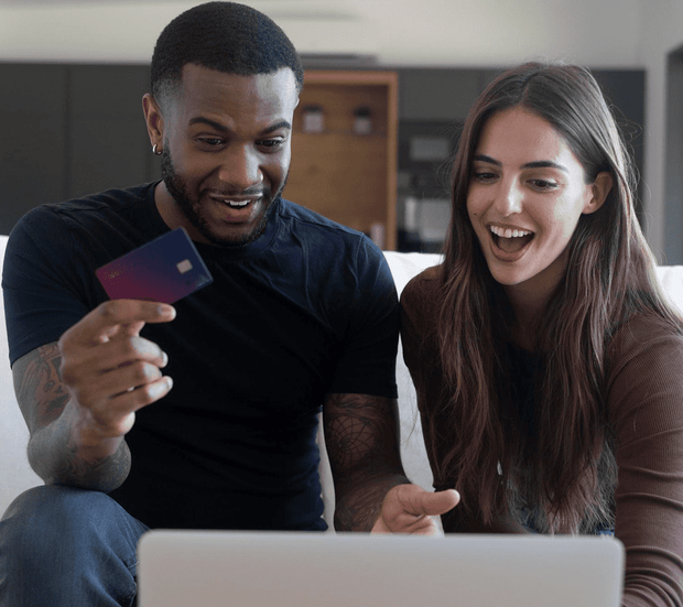 Man and woman using a laptop with a bank card