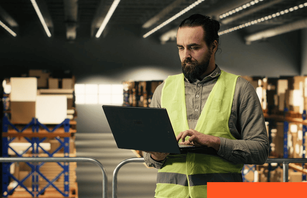 SaaS Development Person working on a laptop in a modern workspace