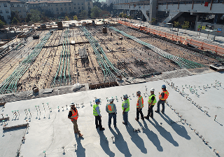 Construction Construction workers standing on a building site seen from above