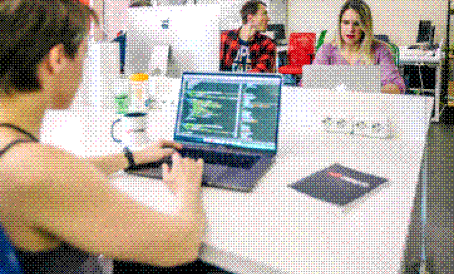 Custom software development in Vancouver Integrio team members working together on a laptop in the office
