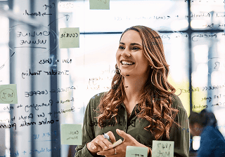 Digital marketing Smiling marketer in front of a whiteboard with sticky notes