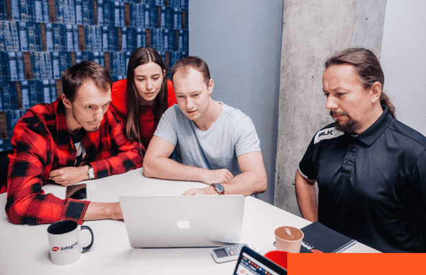 DevOps and CI/CD Automation Professionals collaborating around a laptop