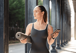 Health & fitness Woman holding a yoga mat and a smartphone