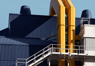 Manufacturing Industrial building with yellow pipes and a steel staircase