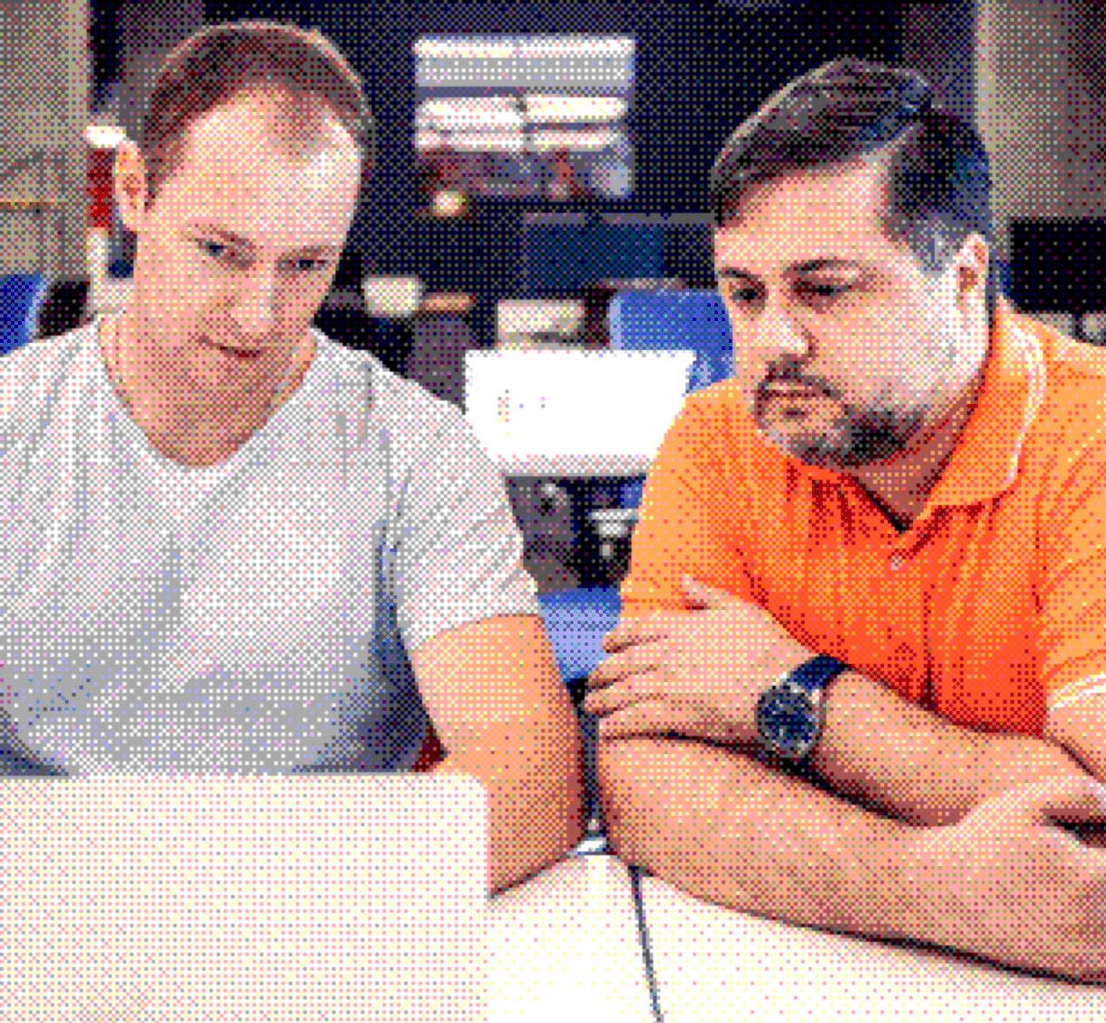 Two colleagues discussing a solution in front of a laptop
